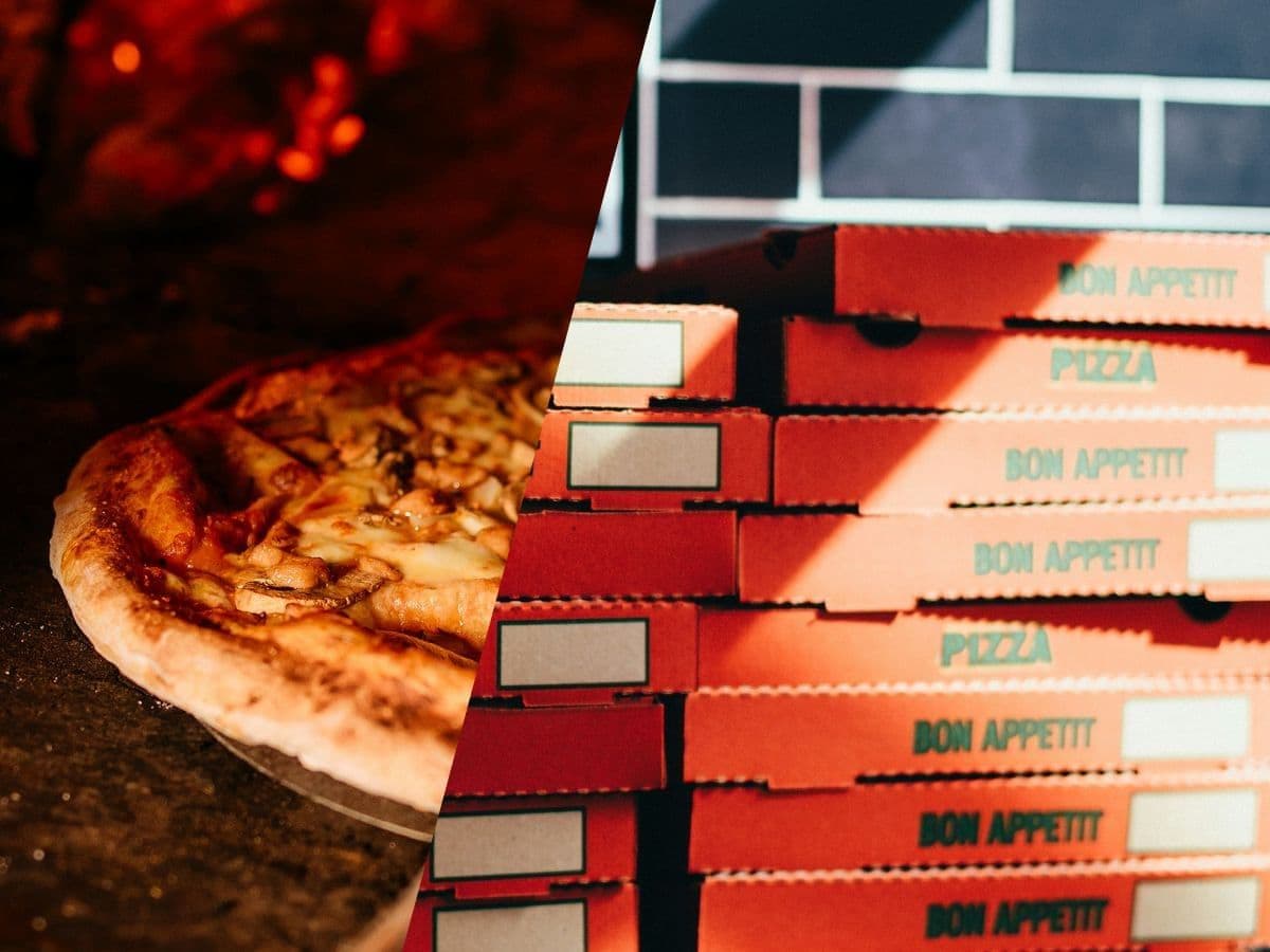 Wood-fired pizza beside a stack of delivery boxes